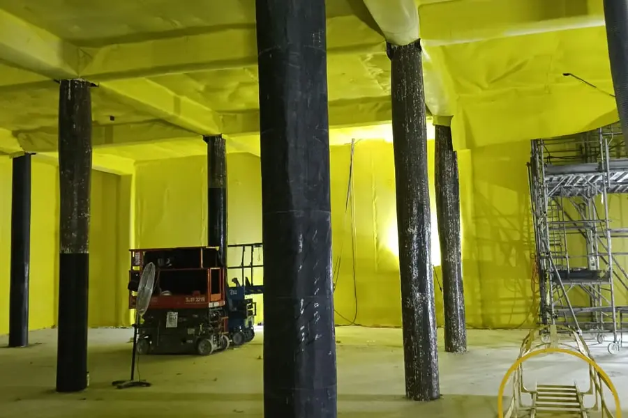 Hall lined in yellow PVC membrane, its concrete columns wrapped in carbon fibre
